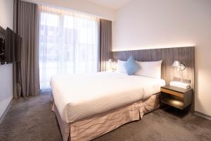 a bedroom with a large bed and a large window at Dandy Hotel - Tianjin Branch in Taipei