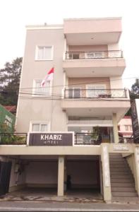 un edificio blanco alto con una bandera. en KHARIZ HOTEL en Bukittinggi