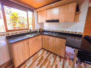 una cocina con armarios de madera y una ventana en Casa Custodia en Ráquira