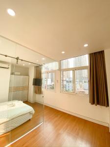 een slaapkamer met een bed en een groot raam bij Aloha House Apartment in Ho Chi Minh-stad