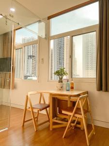 stół i krzesła w pokoju z oknami w obiekcie Aloha House Apartment w Ho Chi Minh