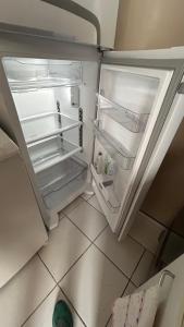 an empty refrigerator with its door open in a kitchen at Tranquilidade in Rio de Janeiro