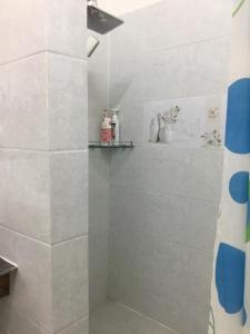 Łazienka z prysznicem wyłożona jest białymi kafelkami. w obiekcie Villa Visay II w mieście Luang Prabang