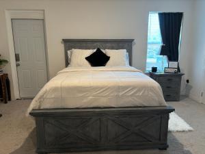 a large bed with a wooden headboard in a bedroom at Luxe Escape in De Leon Springs
