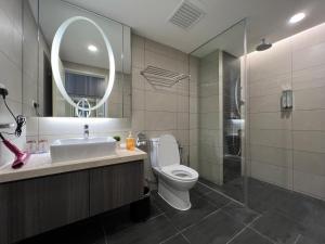 a bathroom with a toilet and a sink and a mirror at QUINCE HOME GRAND ION DELEMEN GENTING HIGHLANDs in Genting Highlands