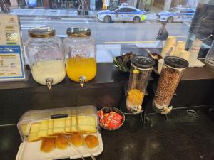 a counter with three jars of orange juice and fruit at Central Park Hotel Busan in Busan