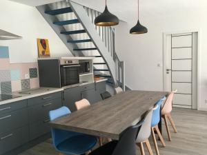 a kitchen with a wooden table and blue chairs at Maison Famille 8 pers, Jardin et Terrasse à Jard-sur-Mer - FR-1-336-104 in Jard-sur-Mer +10 photos