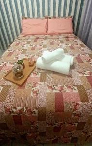 a bed with a quilt with a tray on it at Apartamento próximo a praia. in Laguna