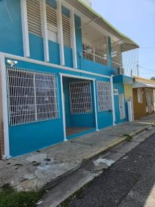 ein blaues Gebäude mit blauen Türen auf einer Straße in der Unterkunft Newly remodeled 3 BR Center Mayagüez, First Floor Unit1 in Mayaguez