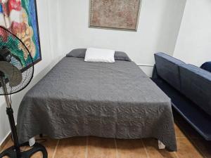 1 dormitorio con 1 cama y 1 sofá azul en Newly remodeled 3 BR Center Mayagüez, First Floor Unit1, en Mayagüez