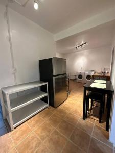 a kitchen with a stainless steel refrigerator and a table at Newly remodeled 3 BR Center Mayagüez, First Floor Unit1 in Mayaguez