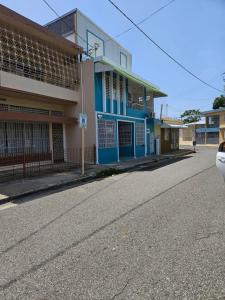 ein blaues Gebäude an der Straßenseite in der Unterkunft Newly remodeled 3 BR Center Mayagüez, First Floor Unit1 in Mayaguez