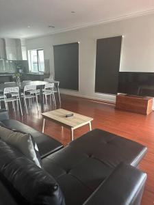 a living room with a couch and a table at Mel south east huge luxury home in Keysborough