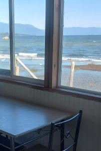 een raam met een bank en uitzicht op de oceaan bij Cabañas piedra azul in Puerto Montt