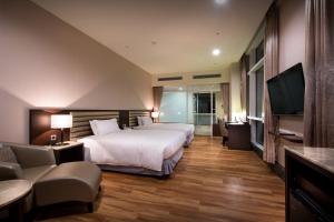 a hotel room with a bed and a flat screen tv at New Taipei Hot Spring Hotel in Xindian