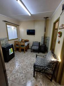 sala de estar con sillas, mesa y TV en CABAÑAS MARISOL, en Valdivia