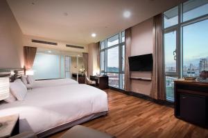 a bedroom with a large white bed and a large window at New Taipei Hot Spring Hotel in Xindian