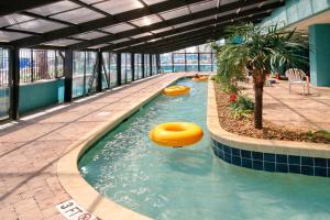 a pool in a building with two inflatable objects in the water at 441 Landmark Resort in Myrtle Beach