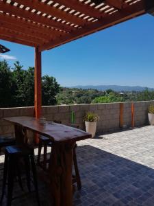 una mesa de madera y sillas en un patio en Rincon de las sierras en Villa Carlos Paz