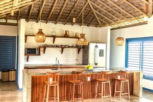 a kitchen with a bar with stools in it at Casa de Praia Perfeita in Fortim