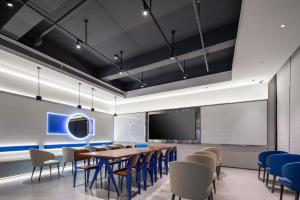 a conference room with a table and chairs and a screen at Atour Light Hotel Zhoushan Dinghai South Renmin Road in Zhoushan