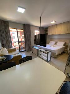 a large room with a bed and a television at Flat central em brasilia in Brasilia