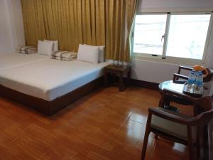 een slaapkamer met een bed, een bureau en een raam bij Jinhua Cold Spring Hotel in Suao