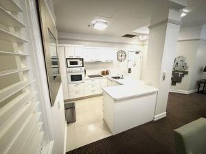 a kitchen with white cabinets and a white counter top at Royal Albert Hotel in Brisbane