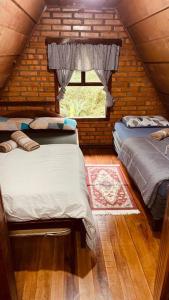 ein kleines Zimmer mit 2 Betten und einem Fenster in der Unterkunft Morro Azul chalés in Timbó