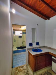 a bathroom with a blue sink and a tub at Lady Mom Hostal in Medellín