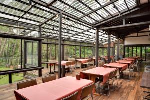 a conservatory with tables and chairs and windows at Village Kagetsuen in Yamanakako