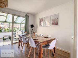 comedor con mesa de madera y sillas blancas en Maison Camaret-sur-Mer, 7 pièces, 8 personnes - FR-1-370-82, en Camaret-sur-Mer