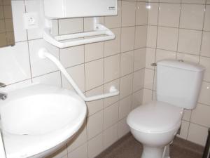 bagno bianco con servizi igienici e lavandino di Hôtel Restaurant de la Dore a Vertolaye