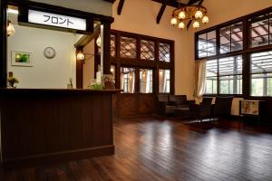 a bar in a room with wooden floors and windows at Village Kagetsuen in Yamanakako