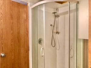 a shower with a glass door in a bathroom at Unique and Charming Garden Cottage/Campervan in Rangataua