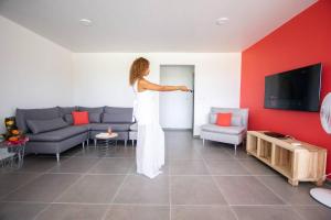 Eine Frau steht im Wohnzimmer in der Unterkunft Séjour Glycéria: Villa Canne à Sucre in Le Marin