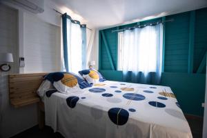 ein Schlafzimmer mit einem Bett mit einer blau-weißen Bettdecke in der Unterkunft Séjour Glycéria: Villa Canne à Sucre in Le Marin + 35 Fotos