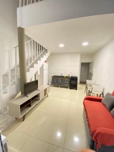 a living room with a couch and a tv at Casa praia 99 in Serra