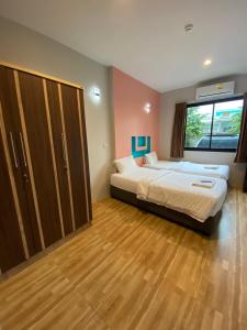 een slaapkamer met 2 bedden en een groot raam bij Nirvana@Phala in Ban Chang