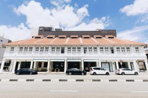 a white building with cars parked in front of it at Santa Grand Hotel East Coast a NuVe Group Collection in Singapore