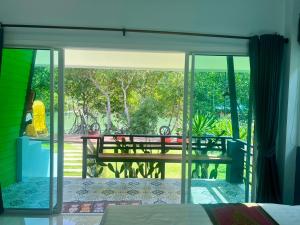 a room with a view of a patio with a bench at บ้านพักชายคลอง @บางปู สามร้อยยอด in Ban Bang Pu
