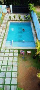 an overhead view of a swimming pool with people in it at Le Grace Kovalam in Chennai