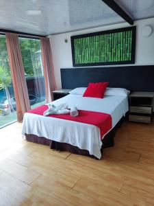 1 dormitorio con 1 cama grande con almohadas rojas en FINCA HOTEL SANTO TOMAS REAL en Rionegro