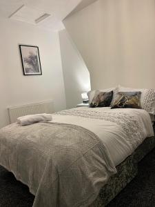 um quarto com uma cama grande num quarto em Comfortable, spacious 2 Bedroom house close to Etihad Stadium em Stalybridge