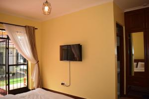 a bedroom with a tv on the wall at Tongas place in Arusha