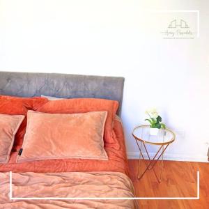 ein Bett mit einer orangefarbenen Bettdecke und einem Beistelltisch in der Unterkunft Dpto en el centro de la ciudad in Santiago