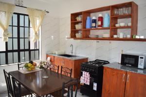 cocina con mesa, fregadero y fogones en Tongas place, en Arusha