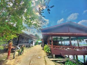 un bâtiment avec un toit bleu à côté d'une rivière dans l'établissement Sun down dondet bungalows, à Don Det