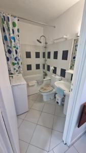 - une salle de bains blanche avec 2 toilettes et un lavabo dans l'établissement Studio magnifique vue mer - Pieds dans l'eau - Bord de plage - Citerne d'eau, au Gosier