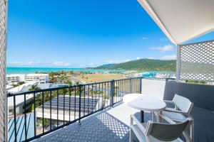 Airlie Beach的住宿－Ocean Views at Whitsunday Terraces Resort，阳台配有桌椅,享有海滩美景。